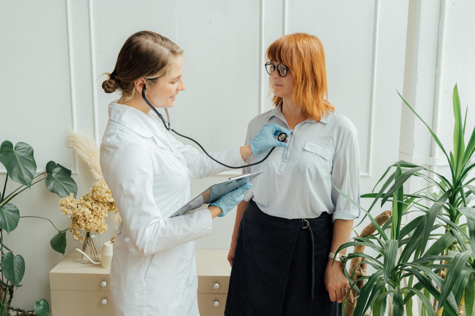 Medical consultation with a doctor using a stethoscope for patient examination indoors.