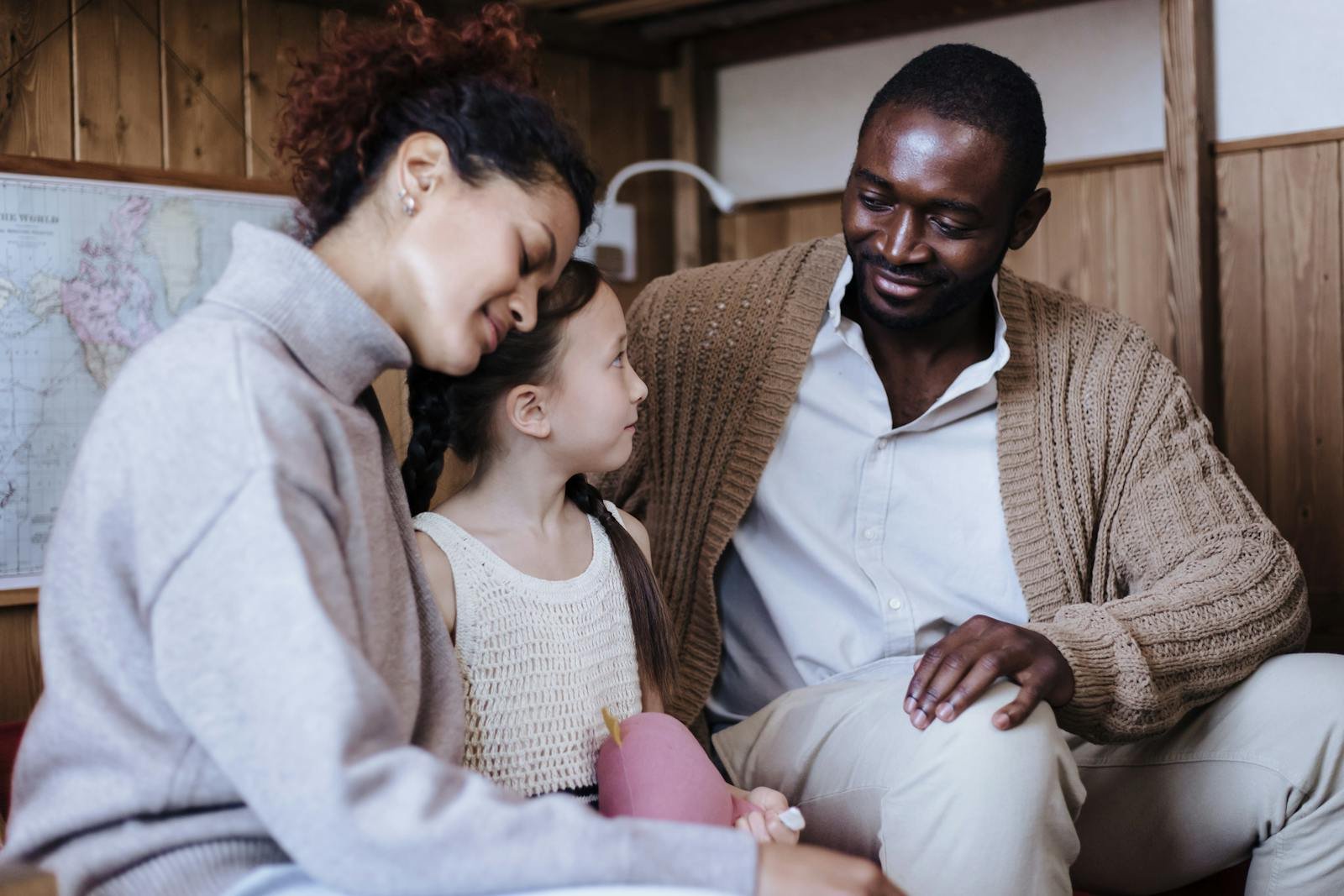 A joyful multiracial family enjoying each other's company in a cozy indoor setting.