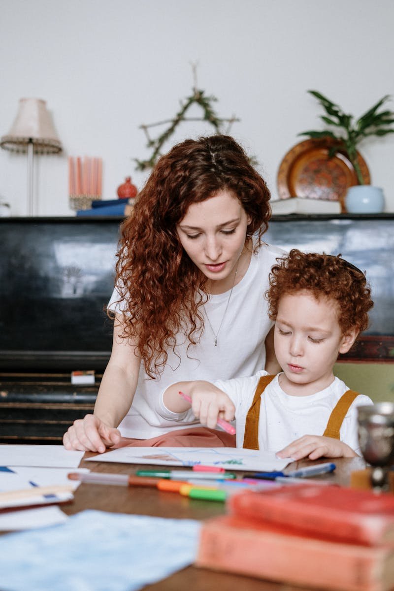 A mother and her son enjoy a drawing activity together at home, fostering creativity and bonding.