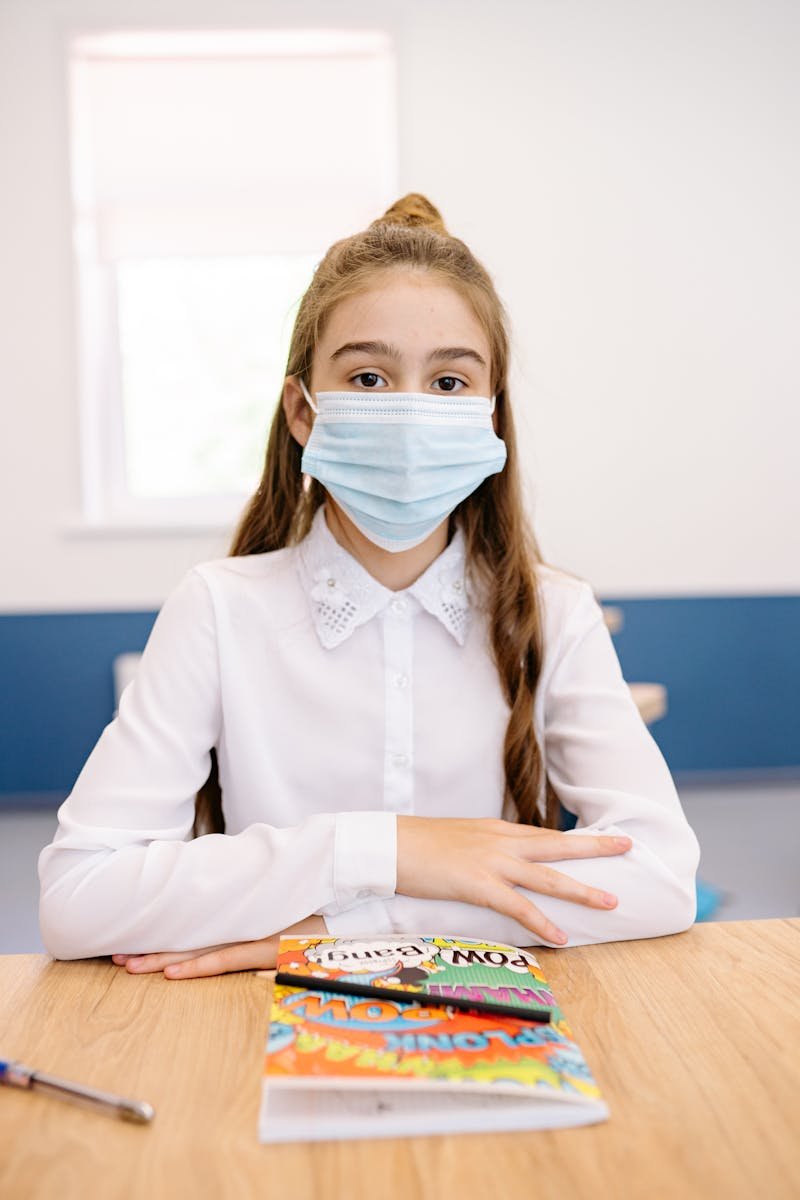 Young girl in school setting, wearing a face mask, representing the new normal during the pandemic.