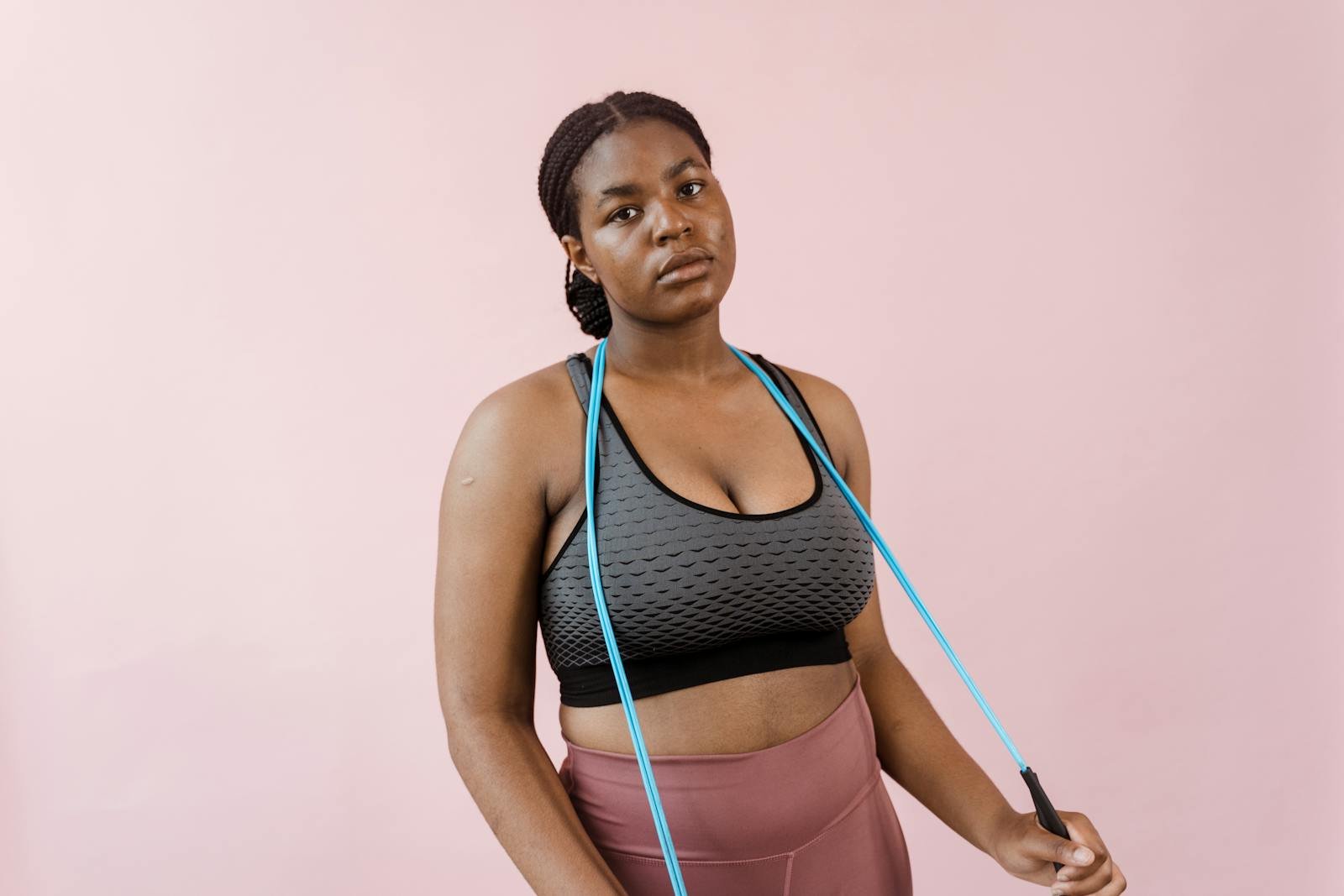 Young woman in stylish activewear using a resistance band during a workout session.