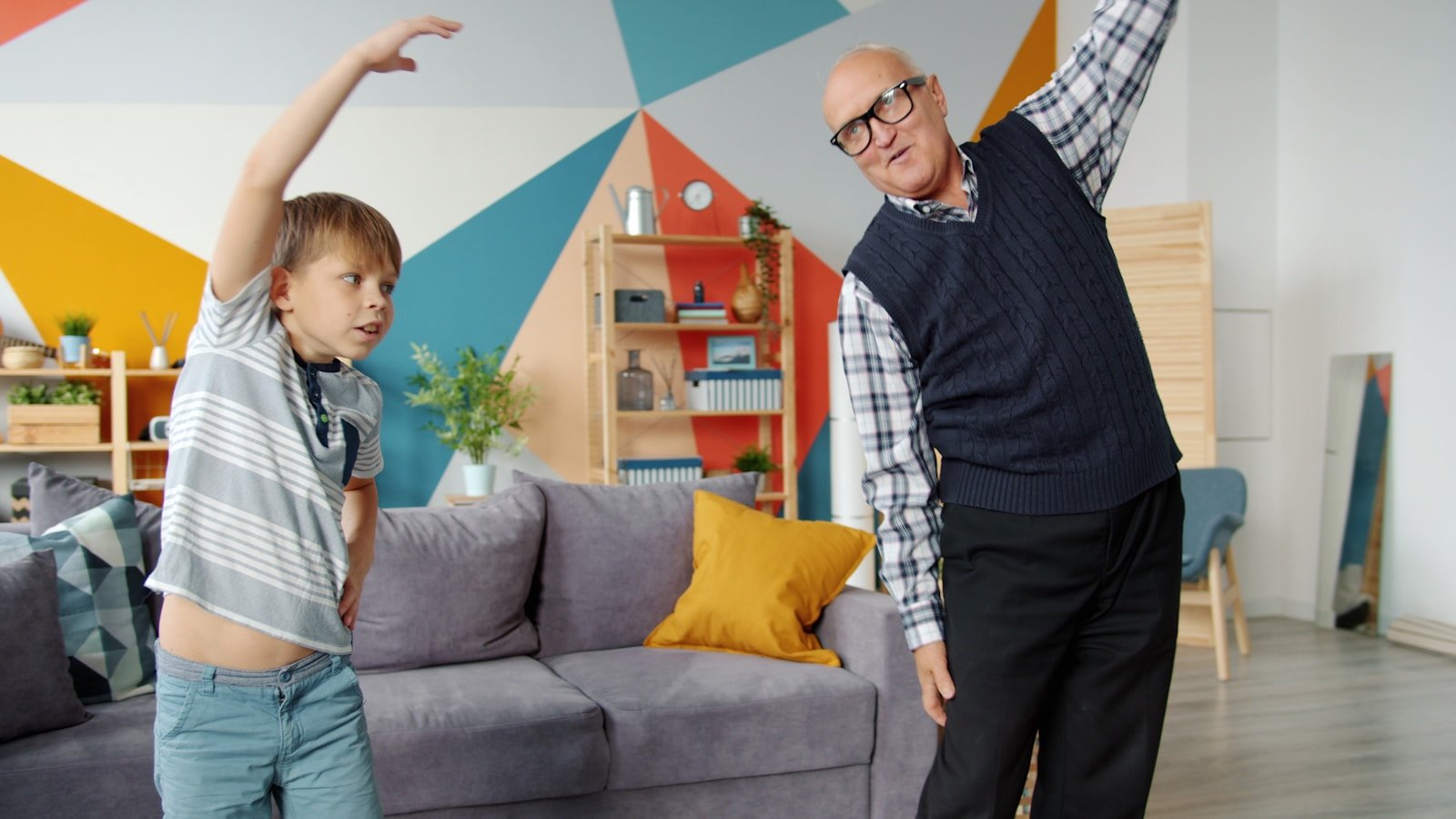 Grandfather and grandson exercising together indoors.